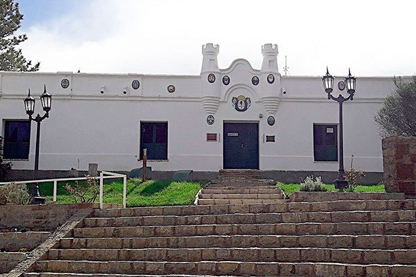 Cliente satisfecho estrechando la mano de un tasador inmobiliario en Chos Malal, simbolizando confianza